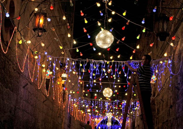 A Palestinian Muslim man, decorates an alley of Jerusalem's old city with festive lights in preparation for the Muslim holy month of Ramadan, Friday, Aug. 21, 2009. The holy month of Ramadan, when observant Muslims fast from dawn to dusk, will begin Saturday. (AP Photo/Muhammed Muheisen)